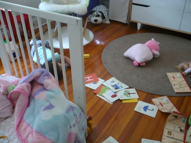 That's her in the blue shirt behind the crib rungs (!)